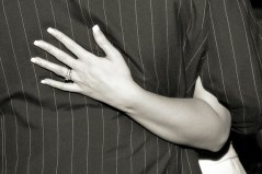 The bride's hand is on the groom's back in black and white.