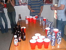 A group is playing / setting up beer pong. 