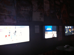 A very dark picture of three screens that made up about half of Melbourne Mana Bar's gaming capabilities. 